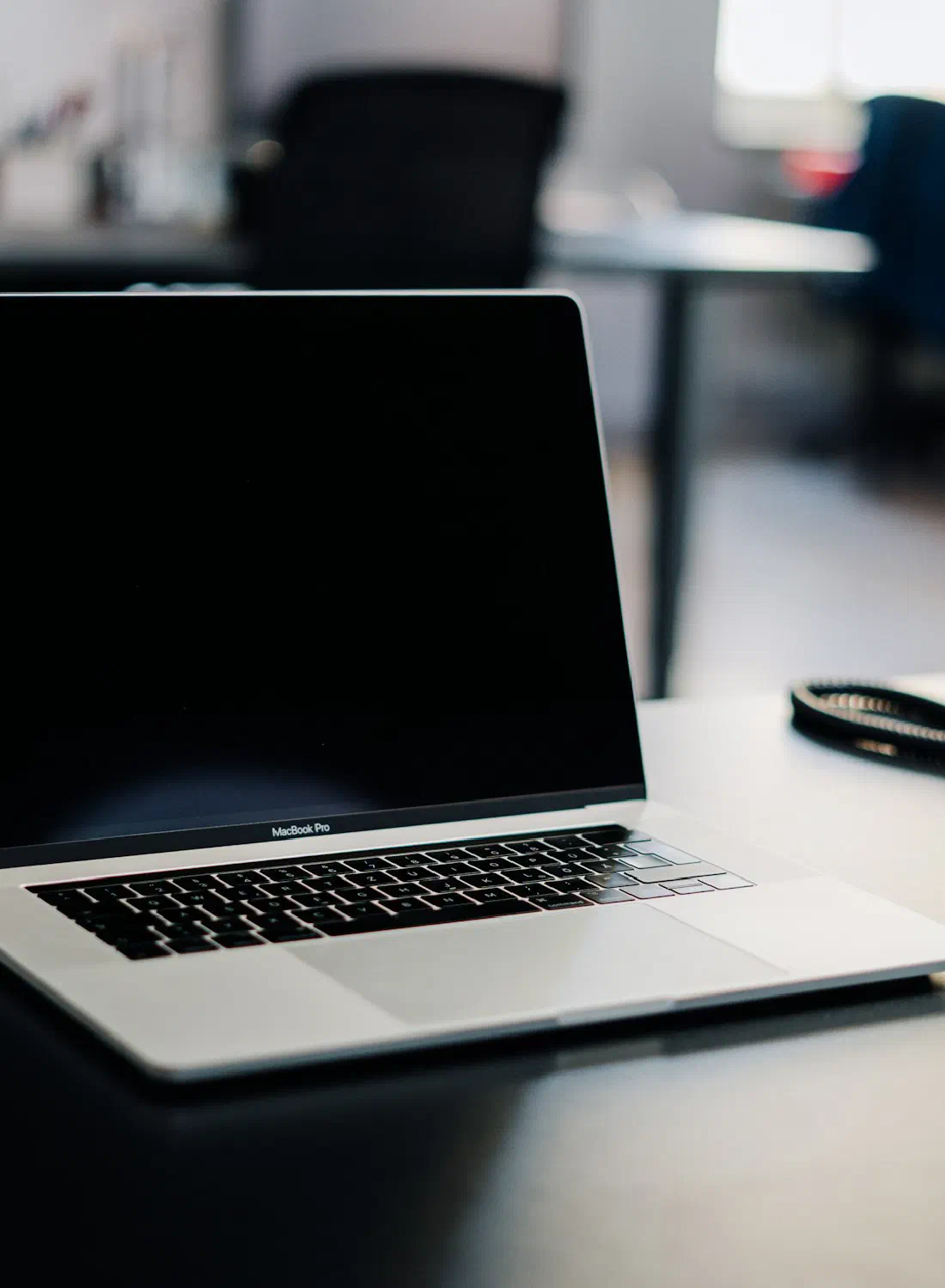 A laptop and a desk phone side by side — the AI channel and the human one