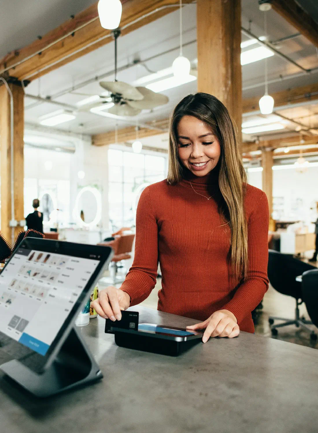 A customer paying by card at a shop counter — the moment commerce happens