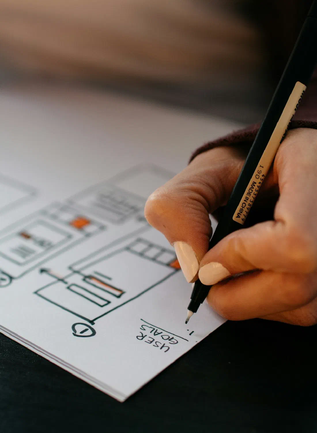 A hand sketching website wireframes labelled user goals — where timelines are really decided